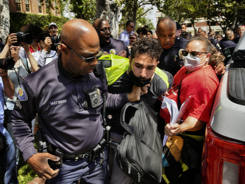 מפגין מאוניברסיטת דרום קליפורניה נעצר על ידי קציני המחלקה לבטיחות הציבור של האוניברסיטה במהלך ההפגנה [צילום: ריצ'רד פוגל/AP]